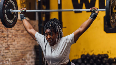 Mujer con una barra haciendo un snatch