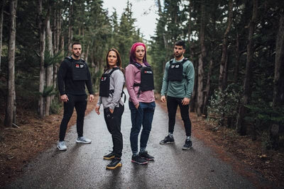 4 atletas de picsil en una carretera con chalecos lastrados puestos.